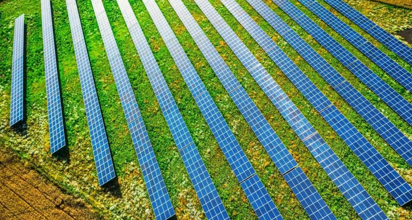 Aerial view of blue solar panels on green field, Poland